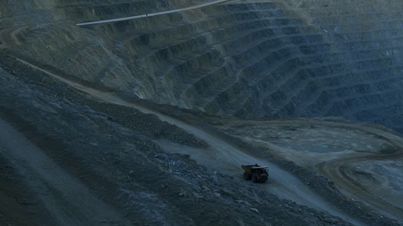 Haul truck climbing out of an open-pit mine at first light