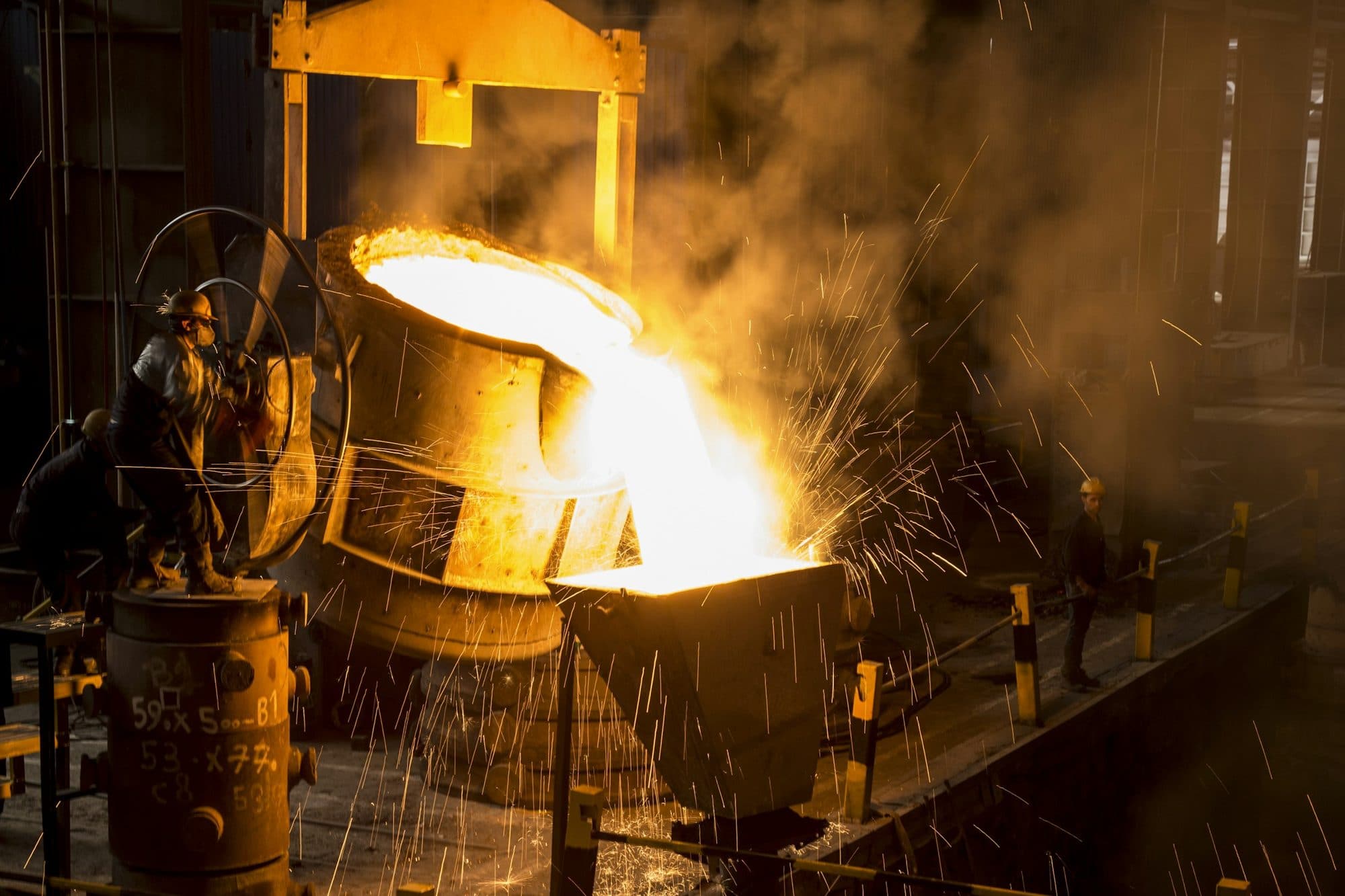 Molten metal poured from a furnace ladle in a smelter